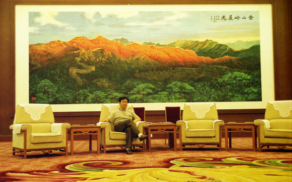 2002年,吴建潮在人民大会堂悬挂的作品《金山岭晨光》前留影