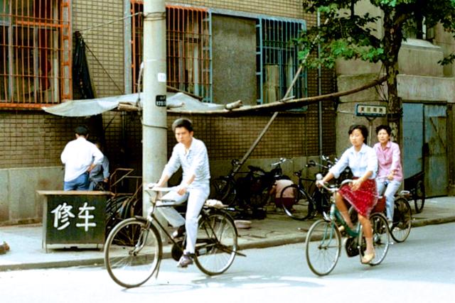 上海街头,穿红色短裙骑自行车的姑娘;拍摄于1987年夏季.