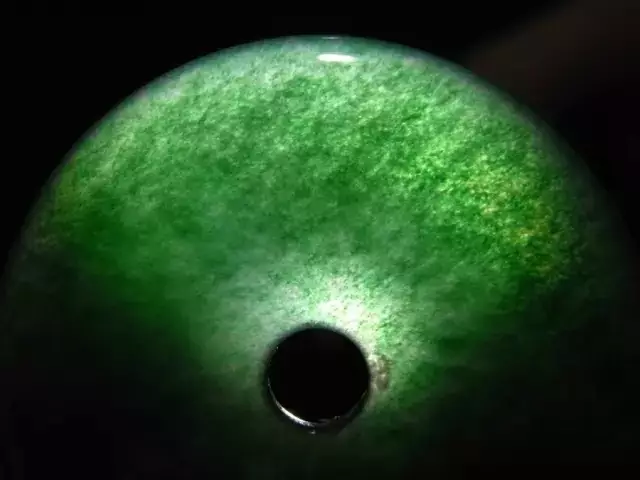 放大镜观察:用十倍放大镜观察,马来玉的绿色呈丝状侵润的染色状态.