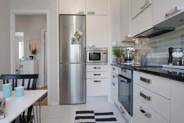 洁白的橱柜,嵌入式的冰箱和微波炉,洗碗机等电器,让厨房看起来更加