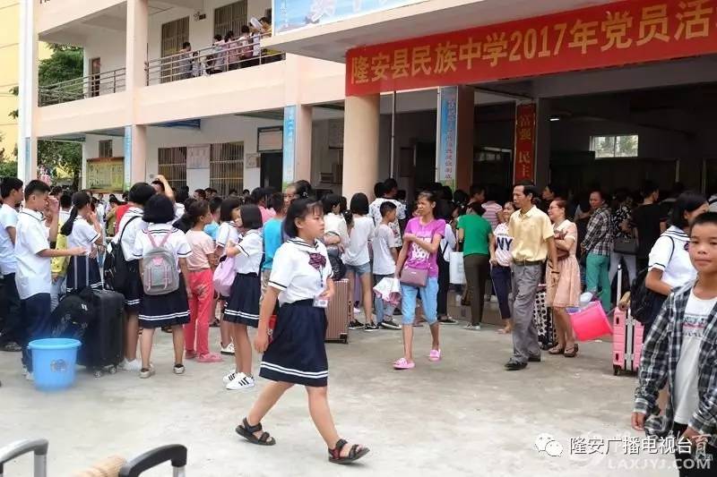 在隆安中学和县民族中学,许多学生和家长排着队,正在办理入学手续.