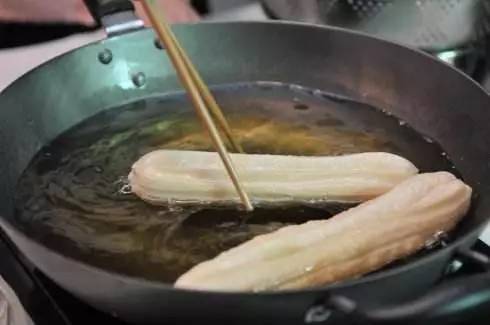 炸的时候要用长筷子搅动一下,保证油条均匀受热,四周都要炸黄为止