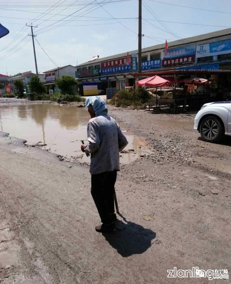 网爆:兰陵县手拄拐杖的老太太在泥泞的道路行走