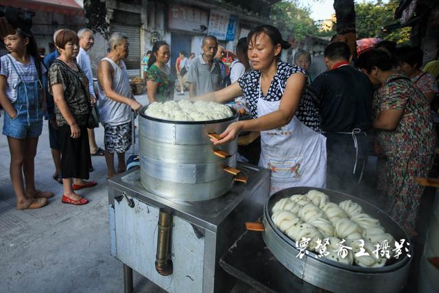 重庆某地的一家早点铺,想吃他们家的包子你得排很长的