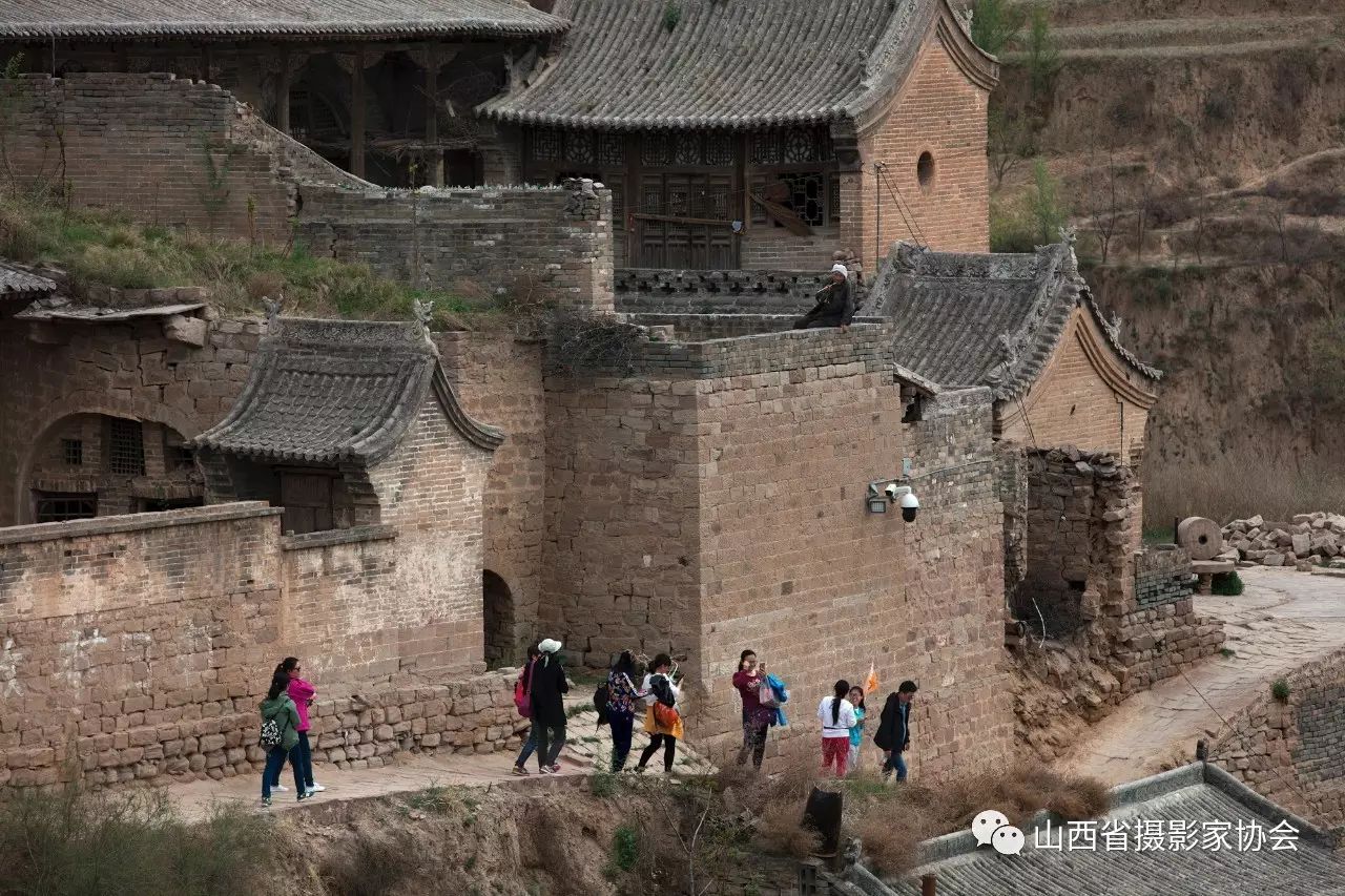 省万荣县阎景村)孟润生摄耙了一上午地的翠英很生气的将风衣递给身