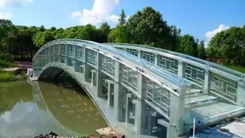 在灵湖龙盘山公园景观区内,一座通透的玻璃桥梁横跨碧水之上,呈现靓丽