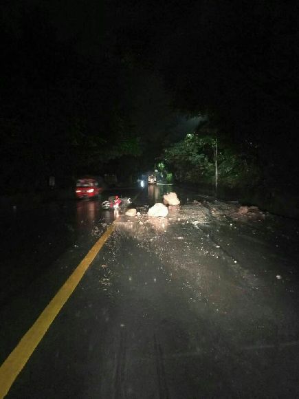 雨夜驾车遇山体滑坡 滚落山石撞翻摩托