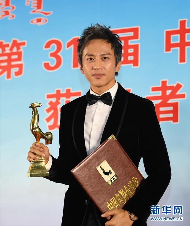 凭借《烈日灼心》获得最佳男主角奖的邓超展示奖杯
