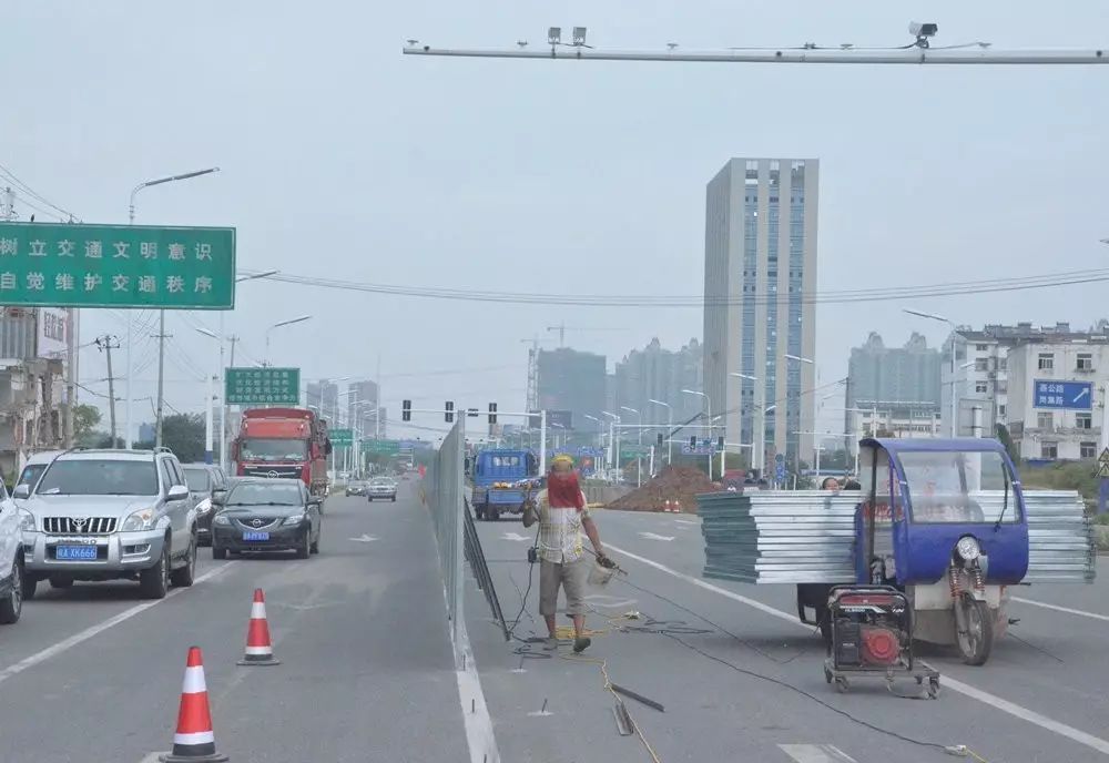 阜阳北路绕城高速附近,工人正在搭建施工围挡