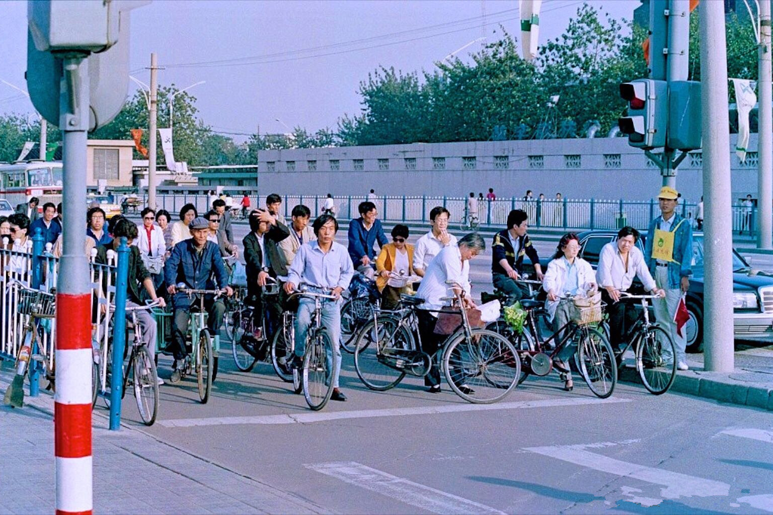 90年代中国珍贵历史老照片:北京街上,人们骑着自行车在马路上等红绿灯