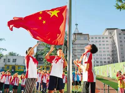 全校师生站在国旗下,行队礼,唱国歌,看着五星红旗缓缓升起,神圣又庄严