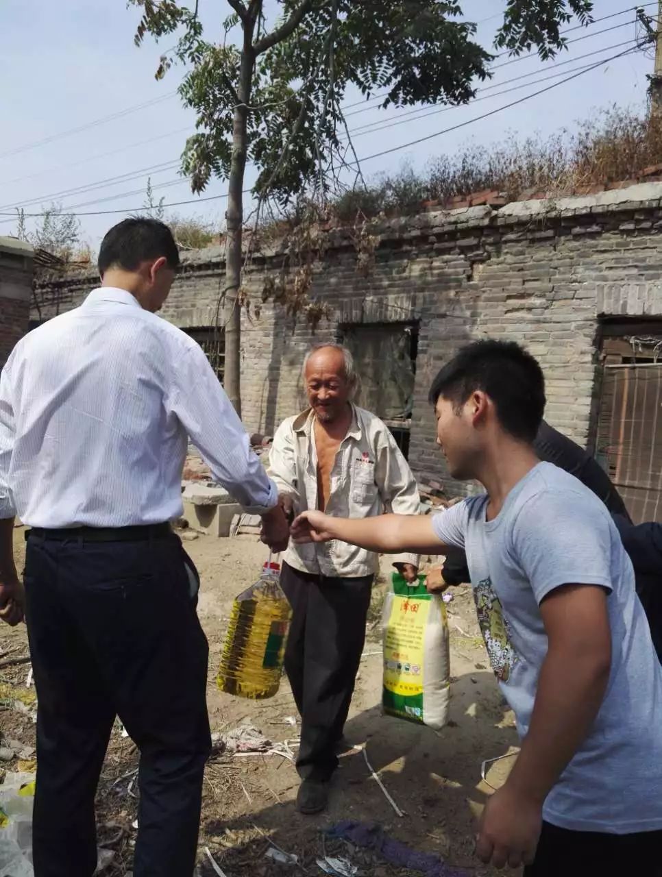 县统计局驻王虎寨镇纸房村工作队走访慰问贫困户,为他们送去大米