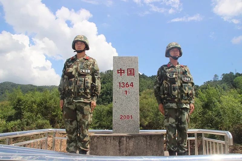 广西防城港市边防支队机动大队官兵界碑旁驻守.