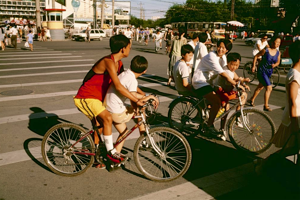 1998年北京历史老照片:北京街头,几个年轻人骑着新式自行车驶过斑马线