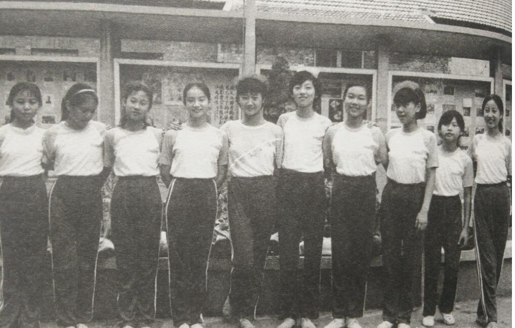 80年代学生历史老照片:10个女同学穿着校服站成一排合影,笑的很灿烂.