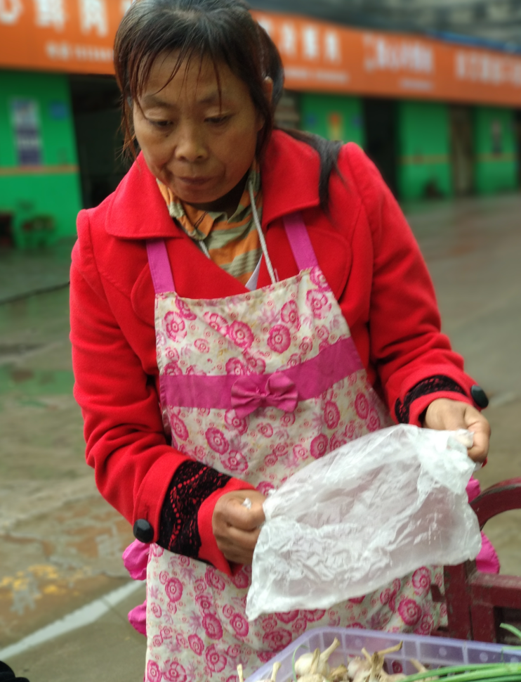 农村大妈雨中卖蒜难销售:只因前些年的"蒜你狠"导致