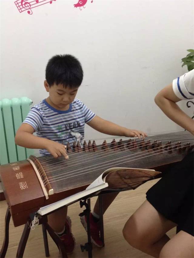 乐学鸿业乐学少年弹古筝的小男孩