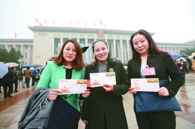 女代表手持十九大纪念邮票