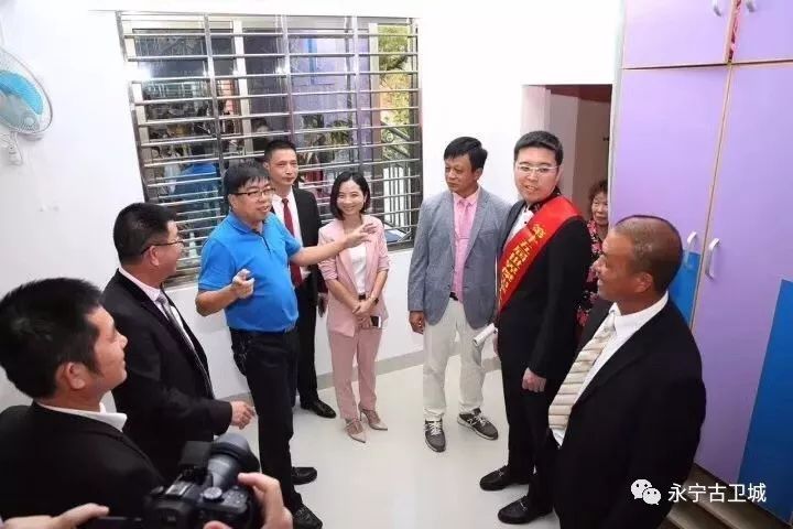 庄永钊,王玉霜老师及庄紫祥博士在他们一家捐建的霞泽小学操场合影镇