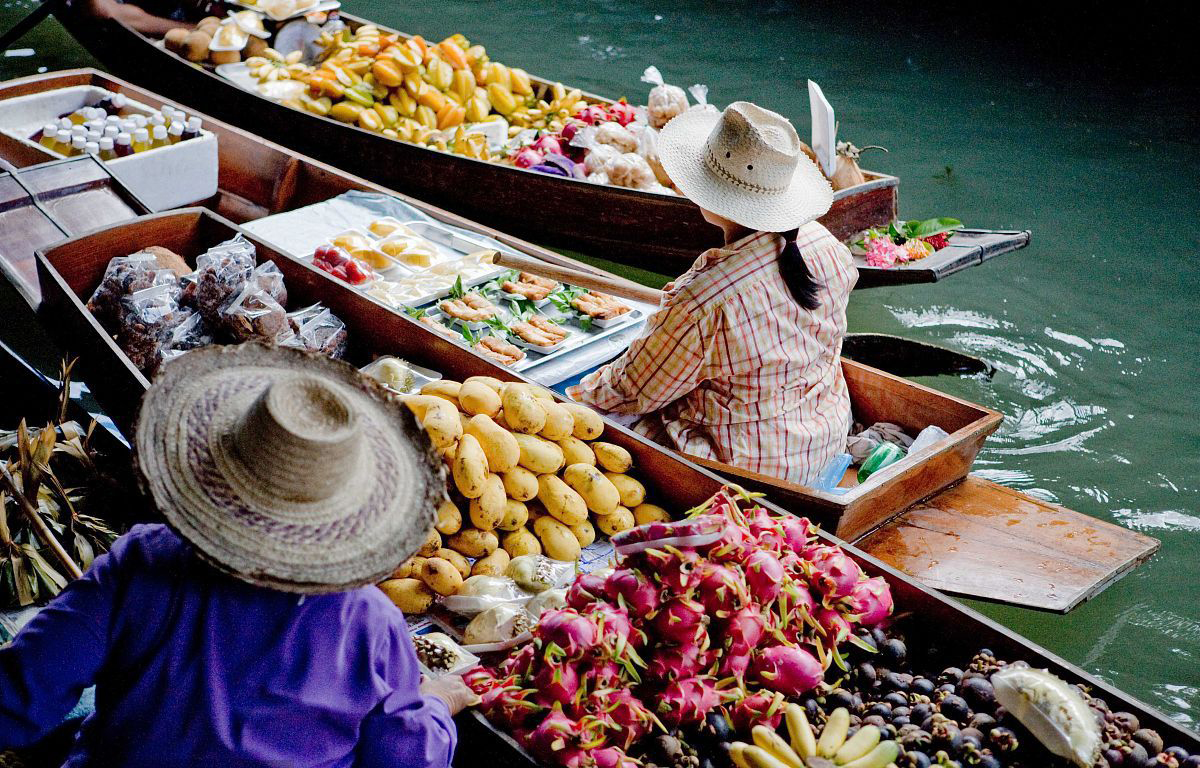 戴草帽在船上卖水果的泰国女人,泰国特色的水