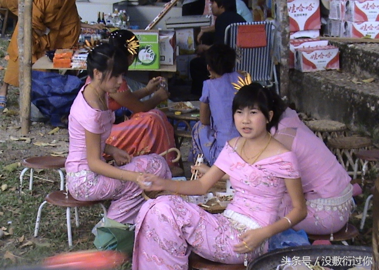 图为正在吃饭的缅甸少女,看她们统一的服装图为街头打伞的缅甸少女,少