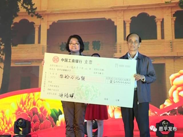 叶婵娟(左)代表独醒中学接收恩平粤怡集团董事长冯活晓(右)的捐款支票