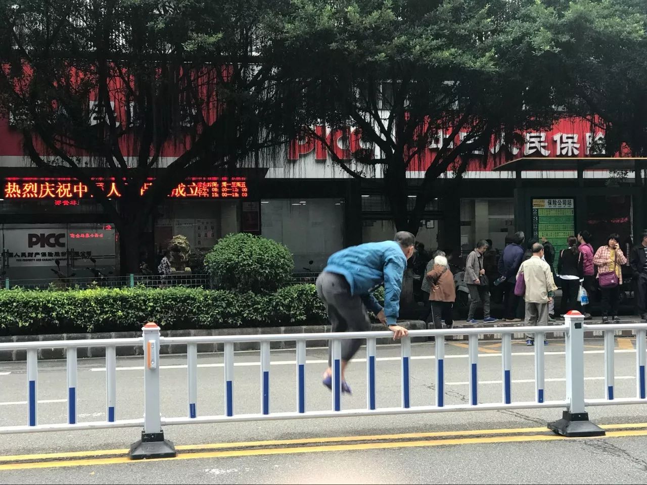 这位大叔径直穿过马路,娴熟翻越路中间的护栏,扬长而去.