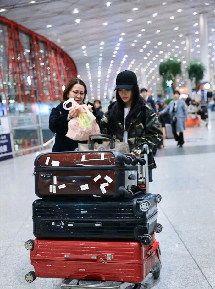 李小璐与妈妈手推行李车,两人走出机场.
