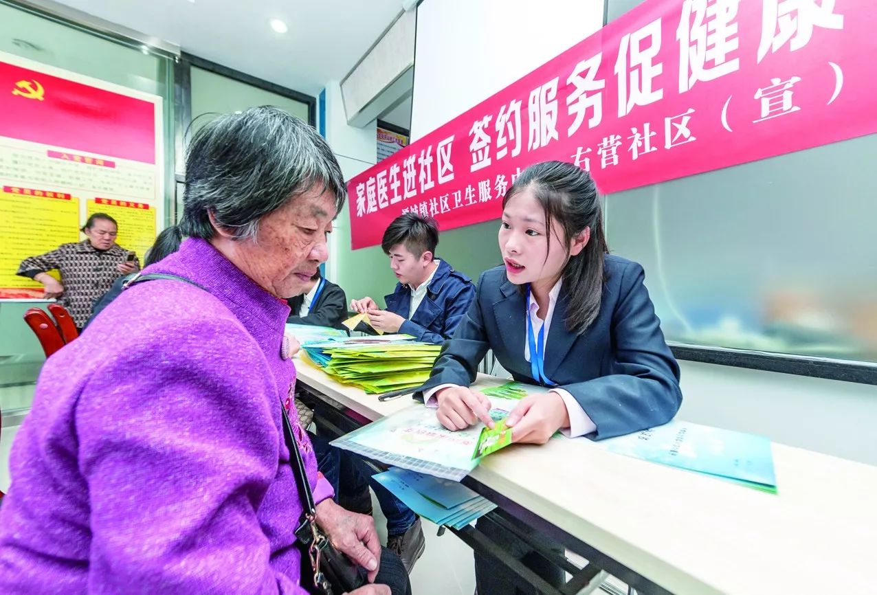 工作人员给社区居民讲解怎样联系"家庭医生"