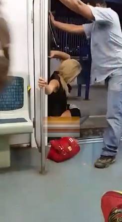 女子乘坐地铁,尿急没憋住,直接在地铁门口解决,绅士的男士还为其阻挡