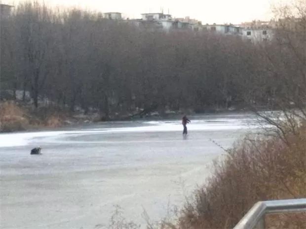 初冬河水刚结冰 就有人迫不及待去溜冰