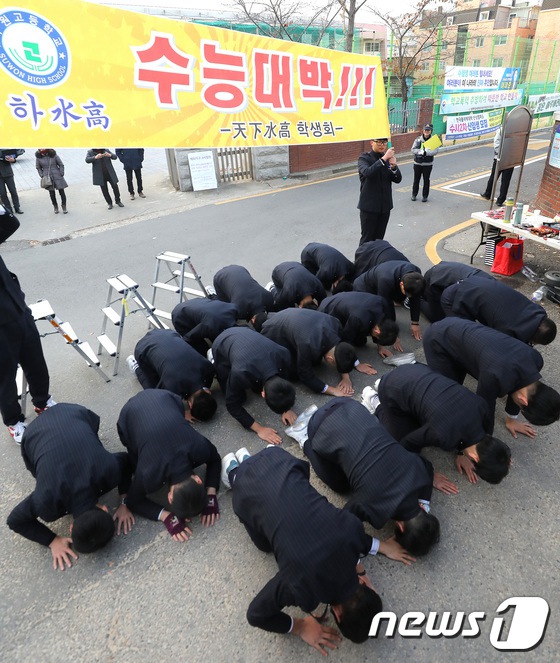 韩国高考当天,位于江原道水原市的水星高中高一高二学生行"跪拜礼"