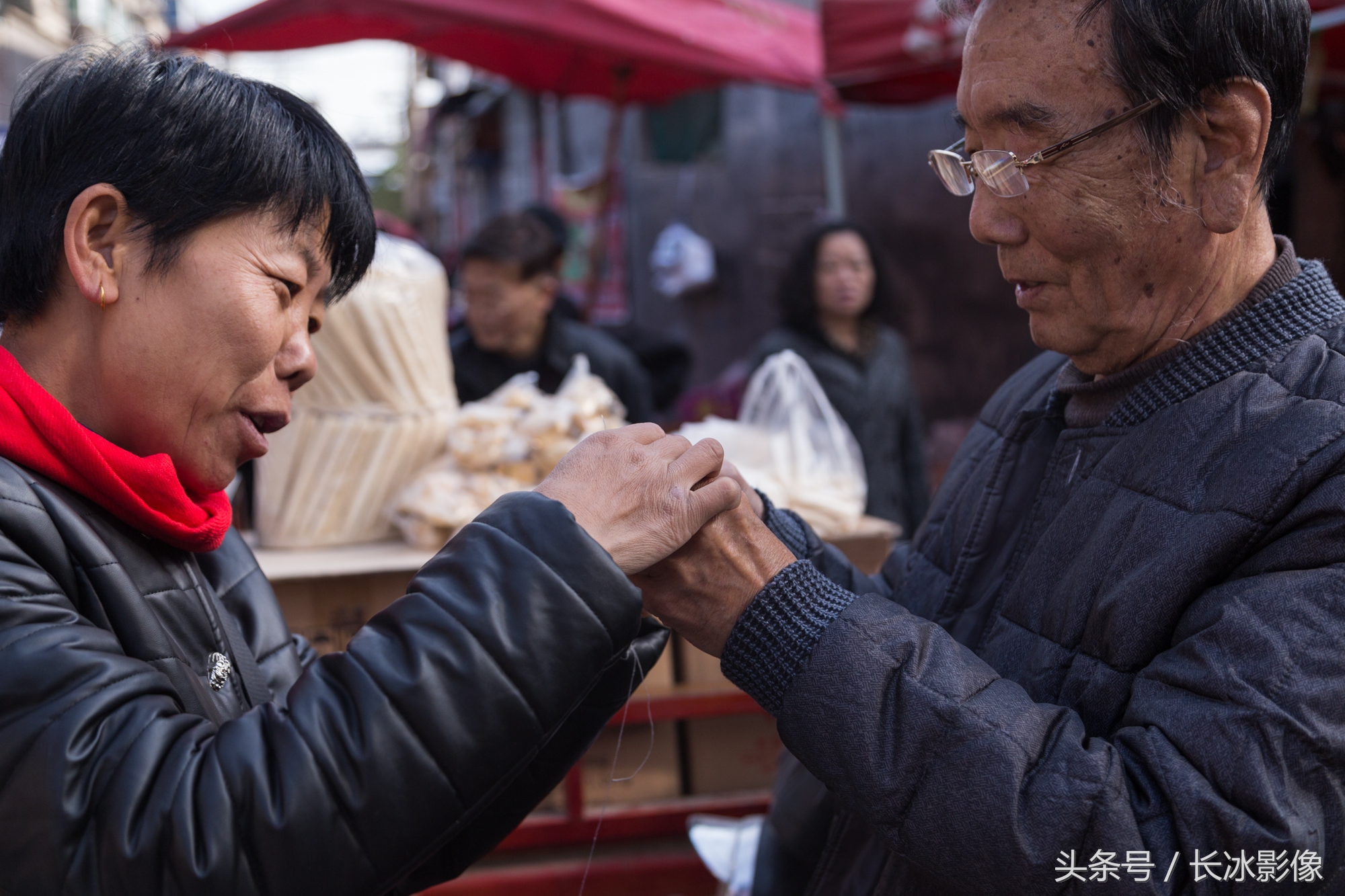 东北大姐西安集市上卖万能穿针器 热情示范深受老年人