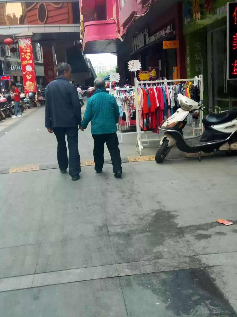 在南康广场天街拍摄了这样一张照片,两个老人手牵手逛街,老爷爷还