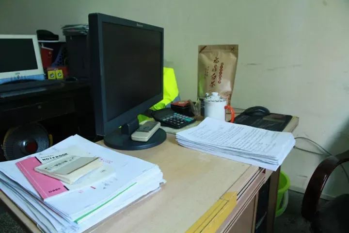 一个不到10平方米的简陋办公室,堆积在小小办公桌上的一摞工作日记