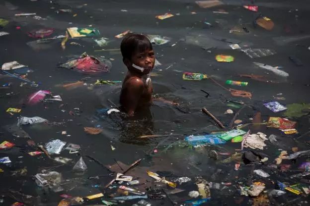 男孩在马尼拉被塑料垃圾污染的水中游泳,图片来源:绿色和平/ daniel