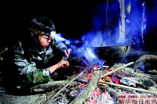 在"扎荒"点,护林员韩雨晨生火做饭(11月17日摄).