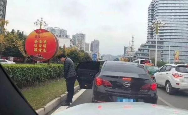 贵州黔西南州兴义市,一名男子在兴义桔山大道路边绿化带随地小便