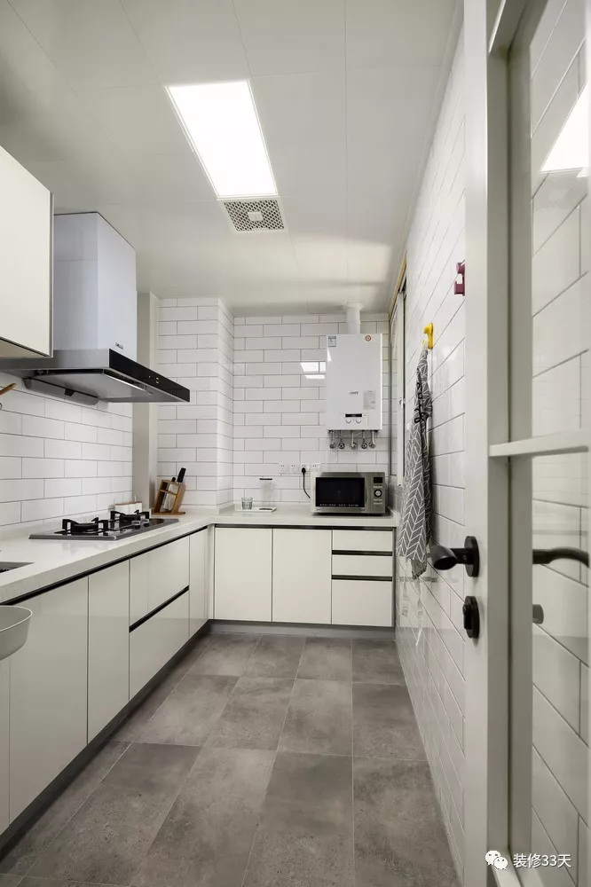 厨房地面通铺灰色水泥砖,墙面采用白色瓷砖工字铺贴,搭配米白色