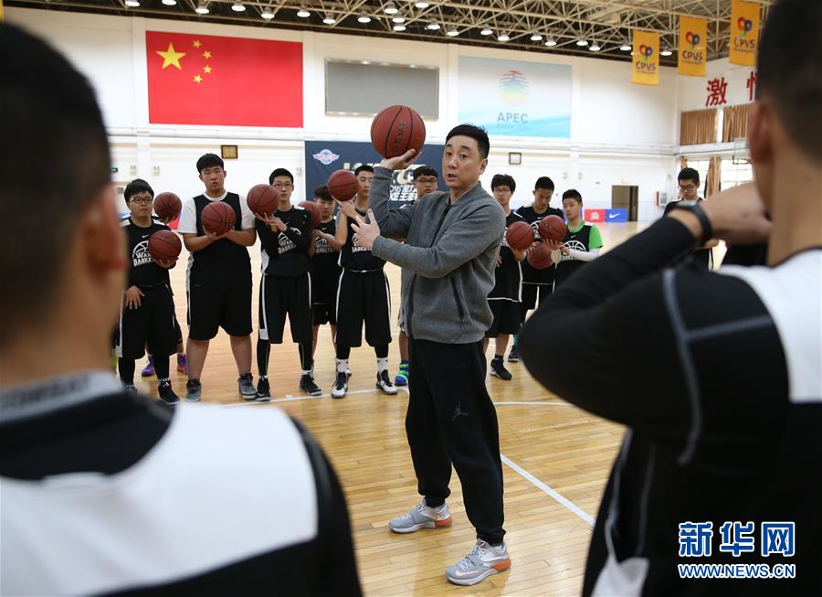这是2016年1月26日,前中国男篮主教练王非(中)为篮球训练营的学员们做