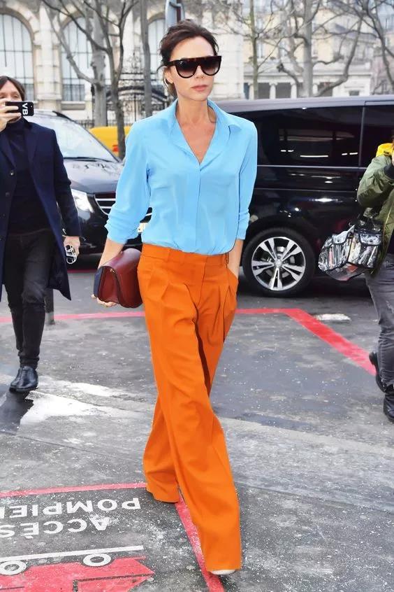 像贝嫂这身浅蓝上衣 橘色长裤的搭配虽然亮眼,但也非常得体显气色.