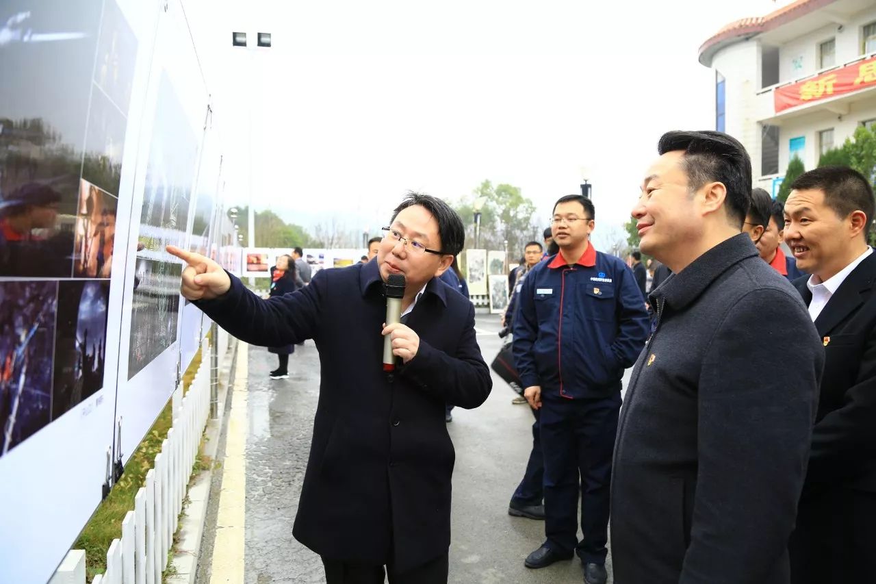 摄影展参观项目读书社,图为严佐魁一行欣赏中铁四局员工原创廉洁漫画