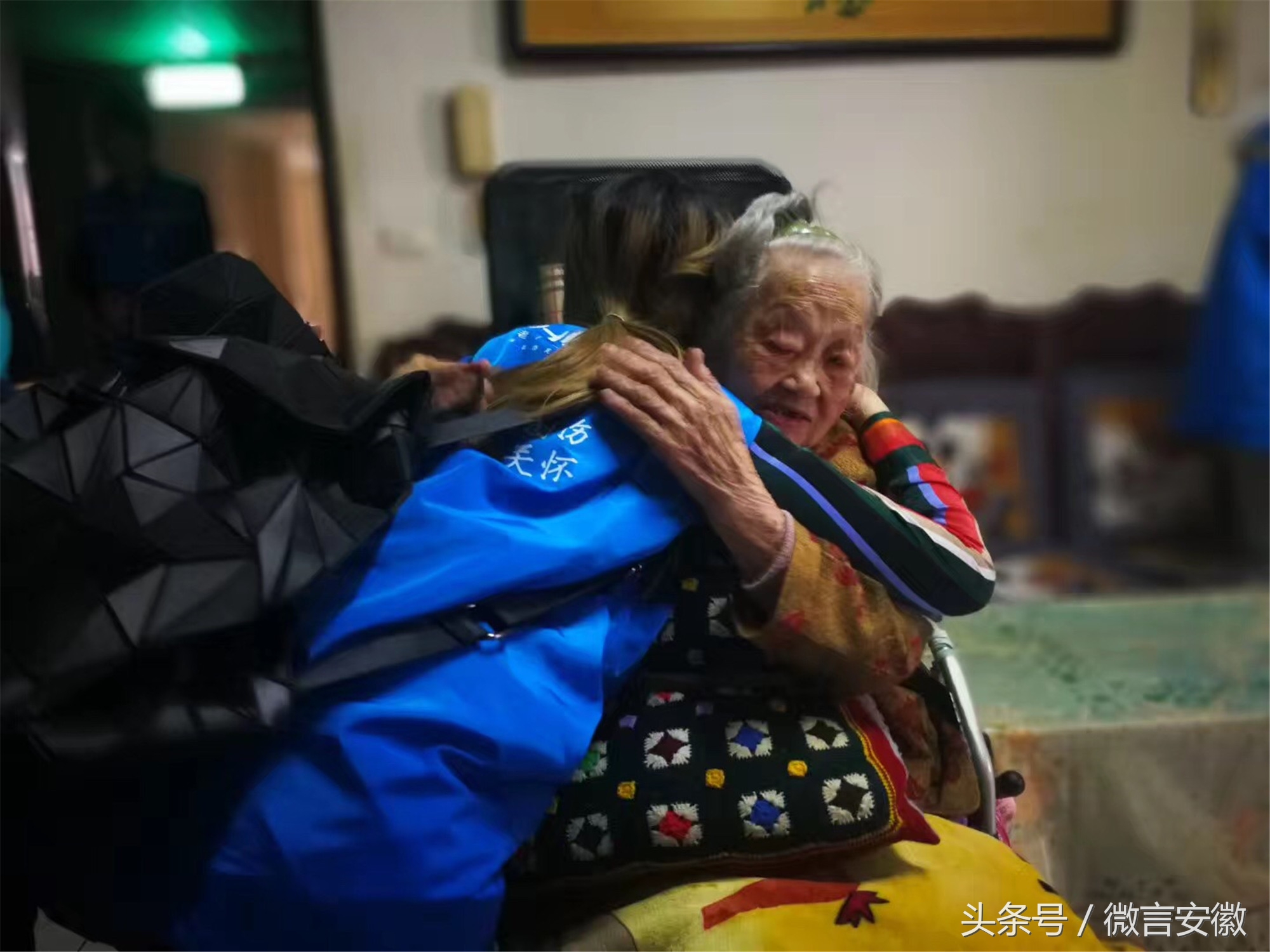 图为12月15日,活动结束后,一位志愿者与老人紧紧拥抱.