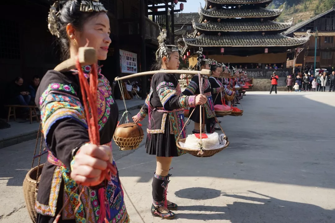 侗家阿哥阿妹将吃食挑至广场