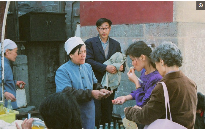 八十年代中国经典历史老照片:图为一个卖汽水的小摊,顾客喝完以后要把