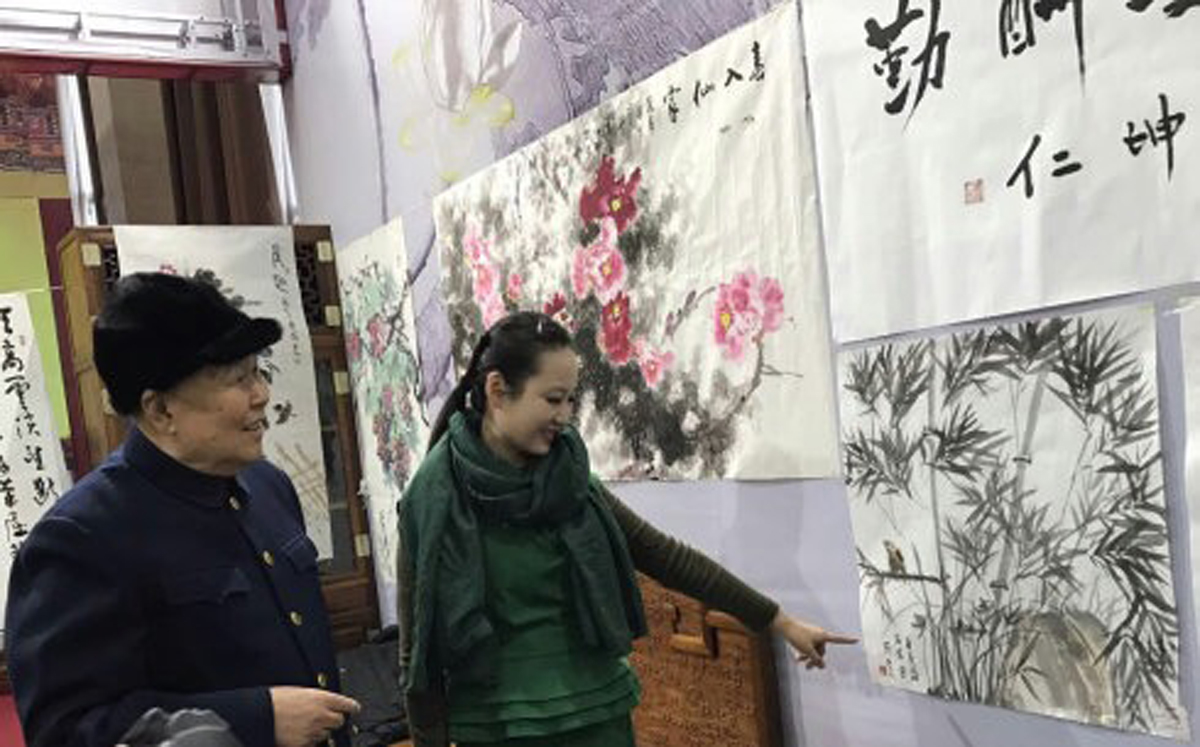 张凡凡向周坤仁上将介绍书画作品