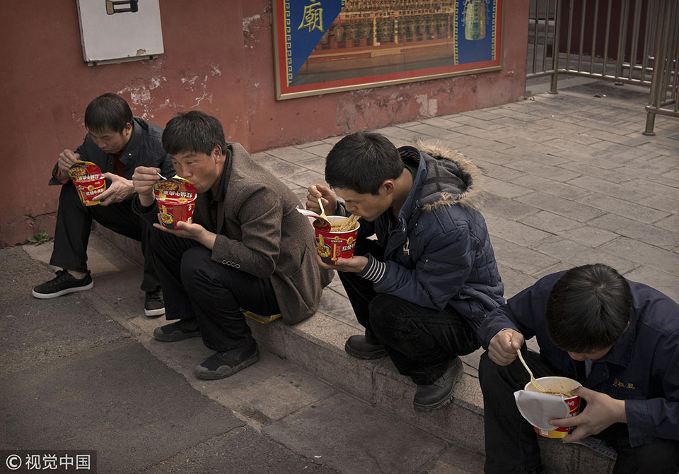2014年3月26日,北京雾霾天,民工在地上吃方便面.