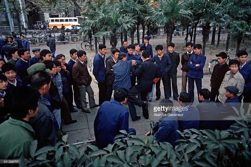 1979年中国历史老照片:图为两个中年男子在起争执,互相推对方,旁边围