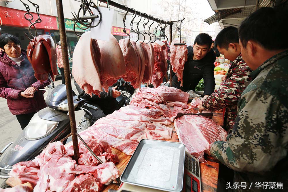 农贸市场肉摊前挤满了买猪肉灌香肠,缠蹄子,做腊肉的市民.