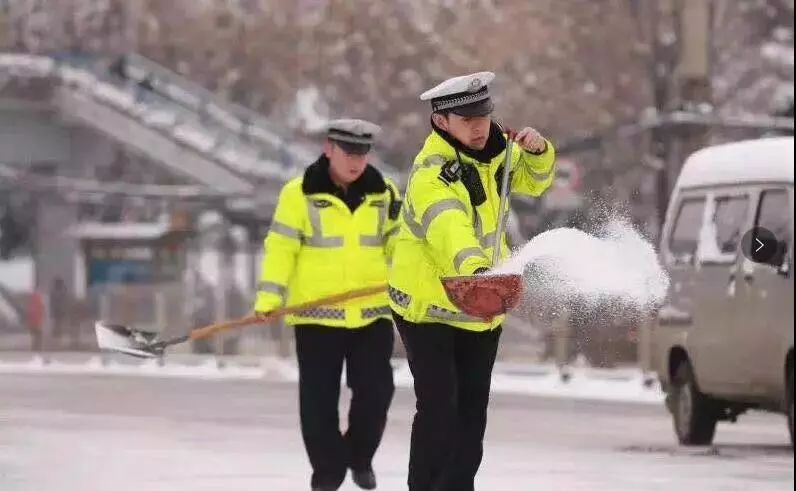 交警同志们撒除雪剂并清扫马路积雪